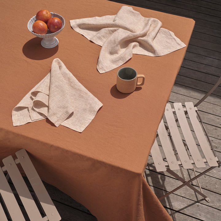 An outdoor table setting featuring a Linen Tablecloth in Cedar paired with Linen Napkins in Cinnamon. Available in Small 150cm x 240cm & Medium 180cm x 300cm.