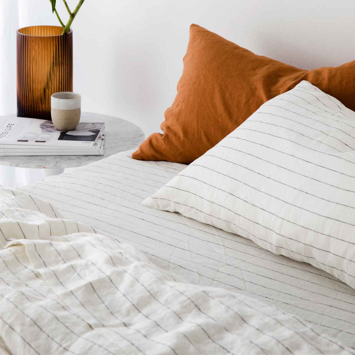 A bed dressed in Pencil Stripe bedlinen, with contrasting Pillowcases in Cedar. Available in Standard & King.