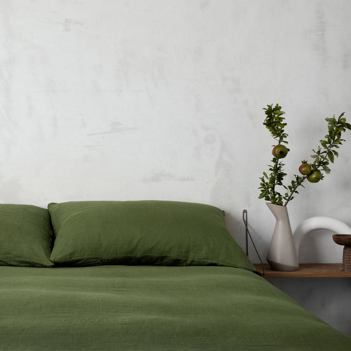 A bed dressed in Forest bed linen, styled with a vase and greenery. Available in Single, Double, King, Super King.