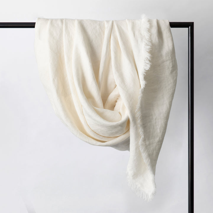 Freya Linen Throw in Snow hanging on a rail