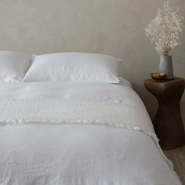 A bed dressed in White bed linen and a Freya Linen Throw in Snow. Available in Single, Double, King, Super King.