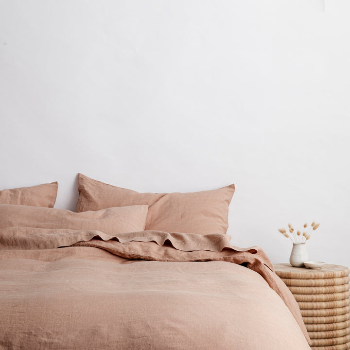 Bed styled with pure linen bedding in Fawn, with a wooden bedside table