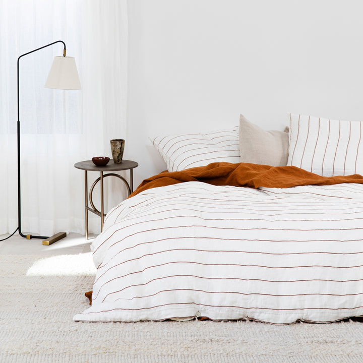 A bed dressed in Cedar Stripe, Cedar and Natural bed linen. Available in Single, Double, King.
