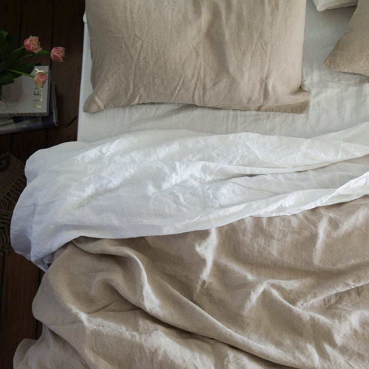A bed dressed in Natural and White bedlinen. Available in Standard & King.