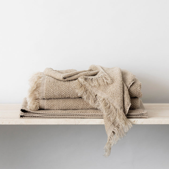 Stack of Pure Linen Towels and a Bath Mat in Natural