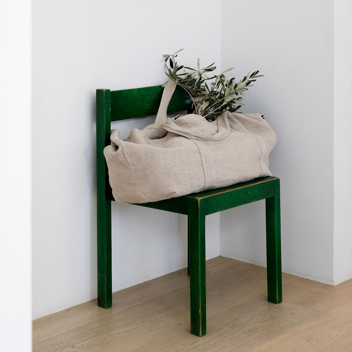 Frankie Linen Bag in Natural colour on a chair with branches inside