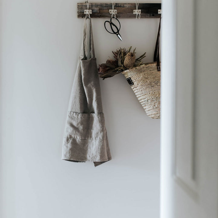 Jude Linen Apron in Natural colour hangs on wall