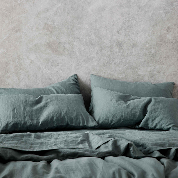 Set of 2 Linen Pillowcases, a Duvet Cover Set and Sheet Set in Bluestone on a bed. Available in Standard & King.